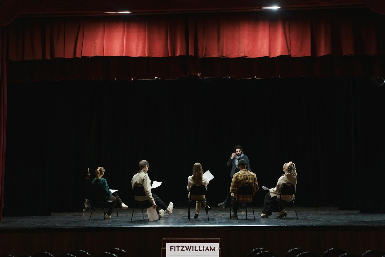 Group of People Sitting on Chair on Stage